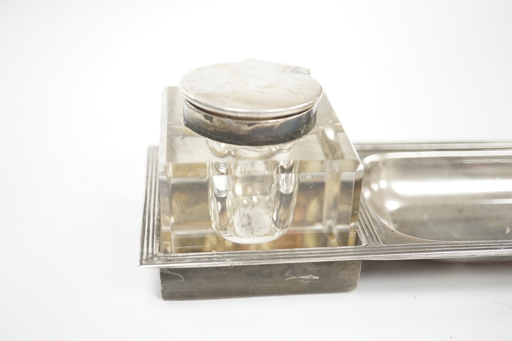 A George V silver rectangular inkstand, with two mounted glass wells and pen recess, John Grinsell & Sons, Birmingham, 1910, length 35.4cm, stand 7.2oz. Condition - fair to good